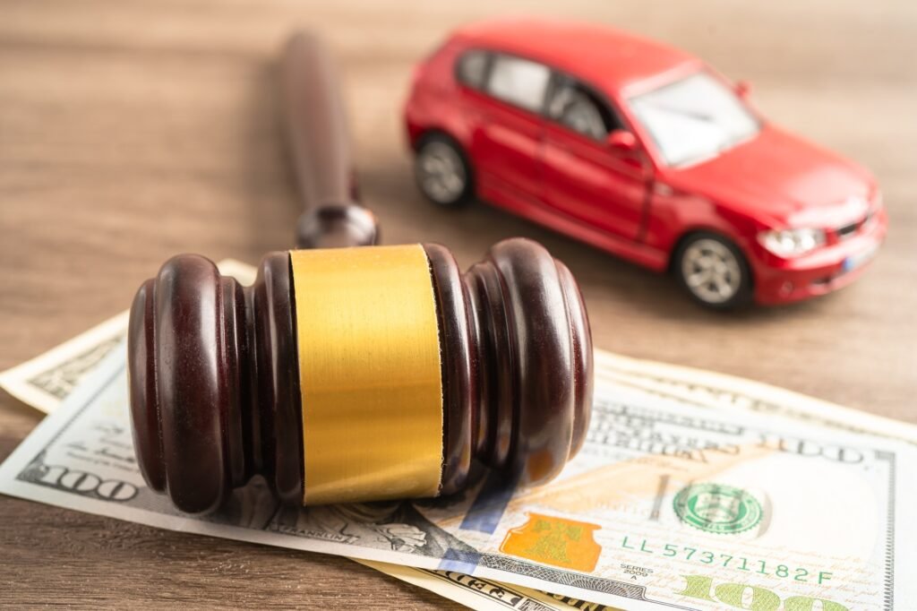 Hammer gavel judge and US dollar banknote money with car vehicle accident, insurance coverage